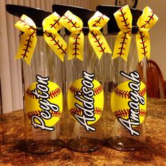 three bottles with baseballs in them sitting on a table