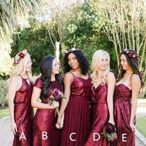 a group of women standing next to each other in long red dresses and holding bouquets