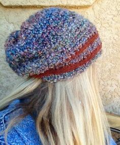 a woman with long blonde hair wearing a knitted hat