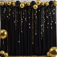 gold and black balloons are hanging from the curtain