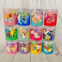 there are many small plastic containers with different toys in them on the white wood floor