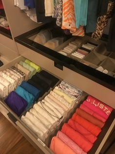 an open drawer in a closet filled with clothes