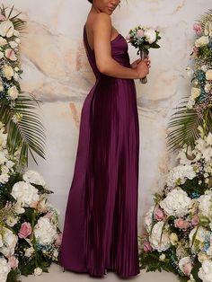 a woman in a long purple dress holding flowers