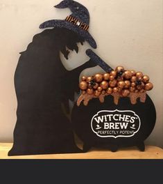 a witches brew sign with a pumpkin and witch hat sitting on it's head