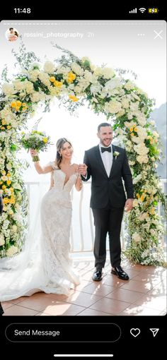 a bride and groom walking down the aisle at their wedding ceremony in front of an arch decorated with flowers