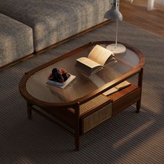 a coffee table with an open book on it in front of a couch and lamp