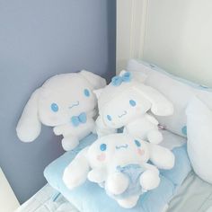 two stuffed animals sitting on top of a bed next to pillows and pillowcases