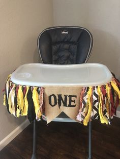 a baby high chair with a one sign on it