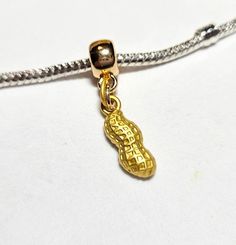 "Golden Peanut Charm - Petite Charm - Goober Charm - Peanut Charm - Dangle Charm- Charm has 3D shape of Peanut although texture only on one side -Fits Pandora and all Designer and European Charm Bracelets  **Charm: 6.35*17.6mm Bail: 11mm( 3/8\") x 5mm( 2/8\")  Hole: Hole size: 4.8mm( 2/8\") 2.5mm (1/8\") Zinc metal alloy  Gold Plated **All orders $45.00 and more receive free shipping within the United States **All orders are shipped immediately from Athens Ohio.  If there is an exception to this Peanuts Charm, Athens Ohio, Snake Chain Bracelets, 3d Shape, Bracelets And Necklaces, Chain Bracelets, Silver Plated Jewelry, Dangle Charms, Pandora Bracelet