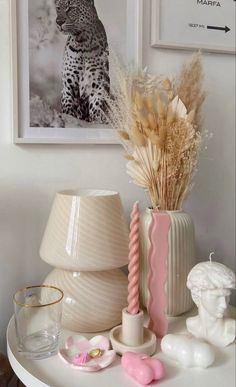 a white table topped with vases filled with different types of flowers and other items