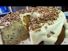 a cake with white frosting and nuts on top