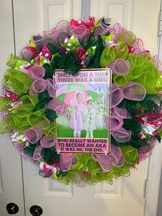 a wreath that has been decorated with pink, green and purple mesh flowers on it