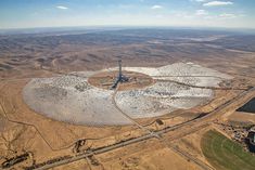 an aerial view of a large solar power plant in the middle of a desert area