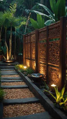 an outdoor garden with stone steps lit up by candles and lights in the dark, surrounded by greenery