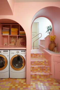 a washer and dryer in a pink laundry room with orange tiles on the floor