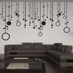 a modern living room with black and white wall decals hanging from it's walls