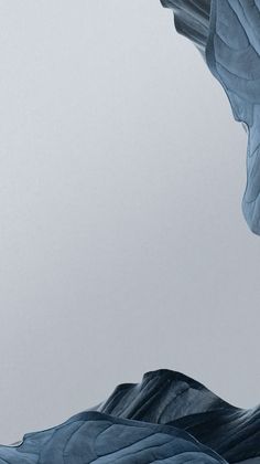 an abstract photo of blue leaves floating in the air on top of mountains and water