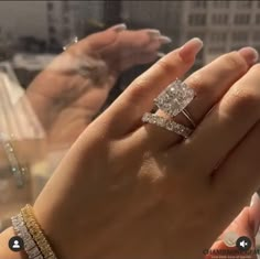 a woman's hand with two diamond rings on it