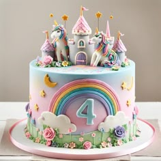 a birthday cake decorated with unicorns, rainbows and stars on top of it