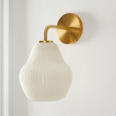 a wall light that is on the side of a white wall next to a door