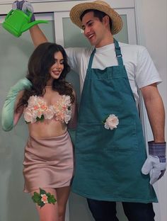 a man and woman dressed up as gardeners posing for the camera with their hands in the air