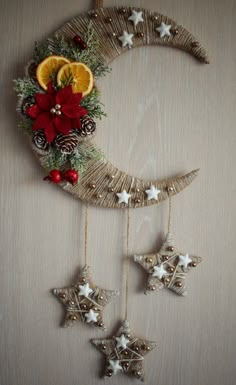 an ornament hanging on the side of a wall with orange slices and pine cones