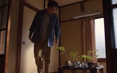 a man standing in front of a table with plants on it