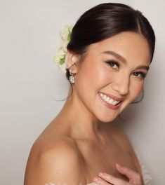 a woman in a wedding dress smiling at the camera