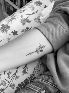 black and white photo of woman's arm with flower tattoos on her left arm