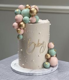 a birthday cake decorated with pastel and gold decorations