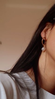 a close up of a person wearing earring's and looking at the camera