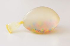 an opalite egg with a yellow ribbon around it's neck on a white surface