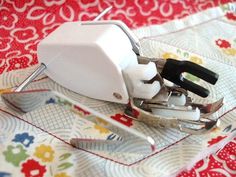 a pair of scissors sitting on top of a piece of fabric next to a stapler