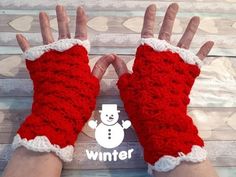 someone wearing red and white knitted gloves with a snowman on it