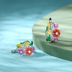 These earrings are cast from sterling silver in the shape of softly bloosm flowers. They're outlined with colorful enamel and dotted with white stones to emphasize the unique shape. These earrings are the epitome of springtime! Perfect for a fairy.Carat Weight: 0.586 ctStone Size: 1,1.7,2 mmNumber of Stones: 40 Stone Shape: RoundStone Color: Diamond WhiteWeight: 5.28 gWidth: 12.6 mmHeight: 18.9 mmThickness: 15.7 mmMaterial: 925 SilverStone Type: Jeulia® StonePlating Color: Silver Rainforest Flowers, Silver Earrings Online, Dreamy Garden, White Stones, Pretty Earrings, Online Earrings, White Stone, Anniversary Sale, Quality Jewelry