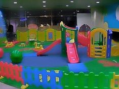 children's play area in an office building with slide and climbing equipment on the ground