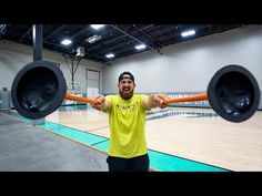 a man is holding two large speakers in front of his face while standing on a basketball court