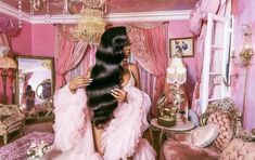 a woman with long hair in a pink room