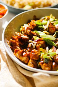 a bowl filled with meat and broccoli on top of a table next to other dishes