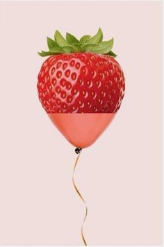 a strawberry balloon floating in the air with a green leaf on it's tip