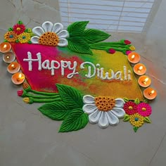 a happy diwali sign with lit candles on the floor in front of it