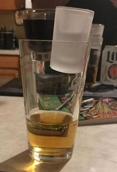 a glass filled with liquid sitting on top of a counter