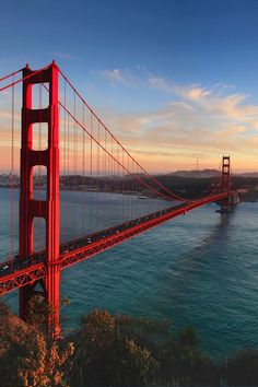 the golden gate bridge in san francisco, california is pictured at sunset as seen from across the bay