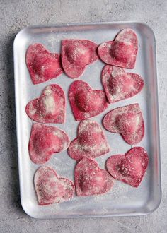 heart shaped cookies on a baking sheet ready to be baked in the oven for valentine's day