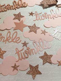 some pink and gold glitter stars are on top of a white table with the words twinkle like