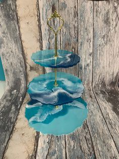 three tiered trays with blue and white designs on them sitting on a wooden surface