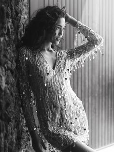 black and white photograph of a woman leaning against a wall