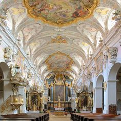 the interior of an old church with many pews and paintings on the ceiling,