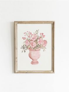 a pink vase filled with flowers on top of a white wall next to a wooden frame