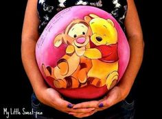 a woman holding a pink ball with winnie the pooh on it's belly